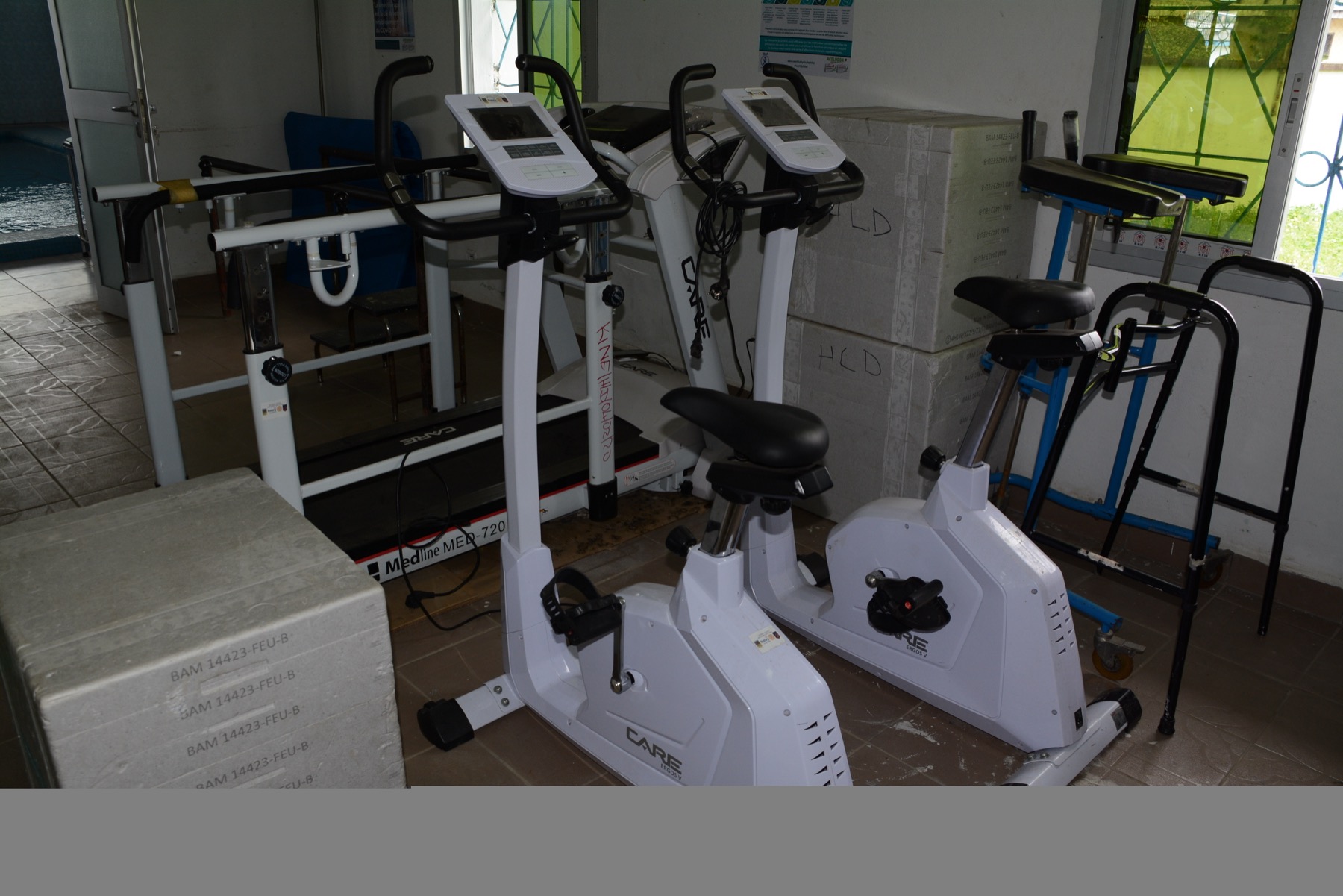 appareils de rééducation : vélos d'exercice, barres parallèles et déambulateur dans un centre de soins